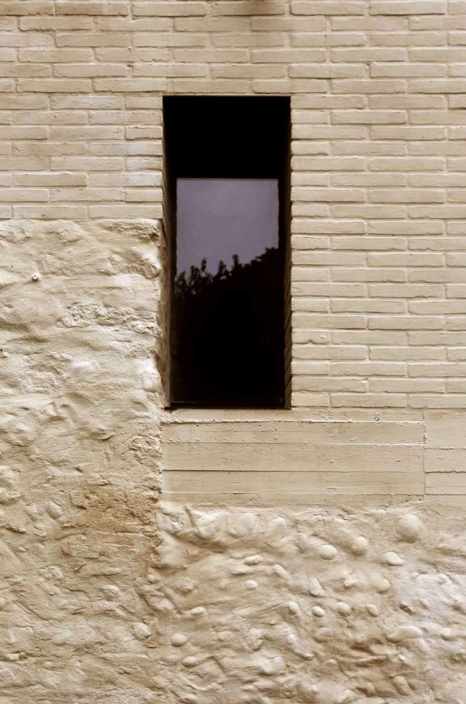 Close-up of freshly applied lime mortar on a brick wall, showcasing its natural texture and color.