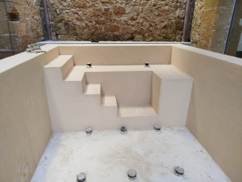 High-angle view of a custom-built swimming pool coated in beige Chukum microcement inside an Alcudia patio.