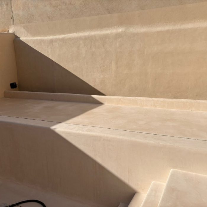 Interior staircase installation featuring smooth, warm-toned Chukum microcement steps under construction.