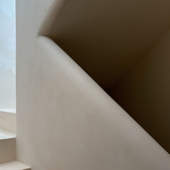 Interior staircase installation featuring smooth, warm-toned Chukum microcement steps under construction.