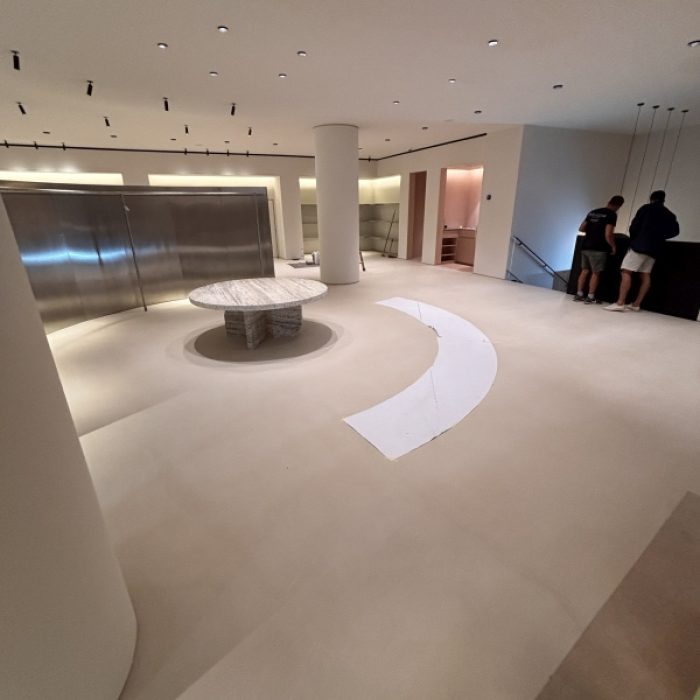 Wide perspective of a large, jointless Mortex retail floor with curved partitions.