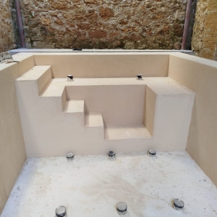 High-angle view of a custom-built swimming pool coated in beige Chukum microcement inside an Alcudia patio.