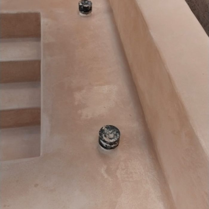 Close-up of seamless Chukum-coated steps inside a renovated courtyard plunge pool.