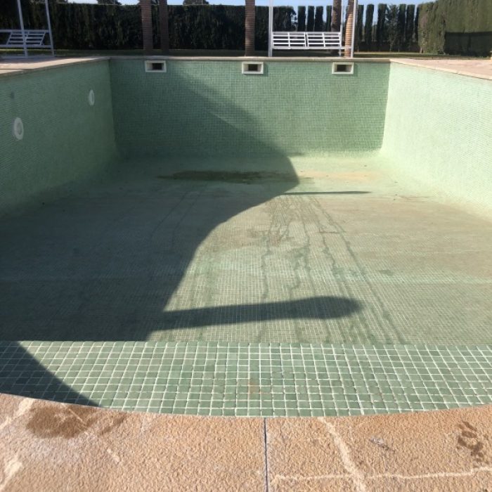 Empty countryside swimming pool showing the subtle textured patterns of a handcrafted Marblepool base before filling.