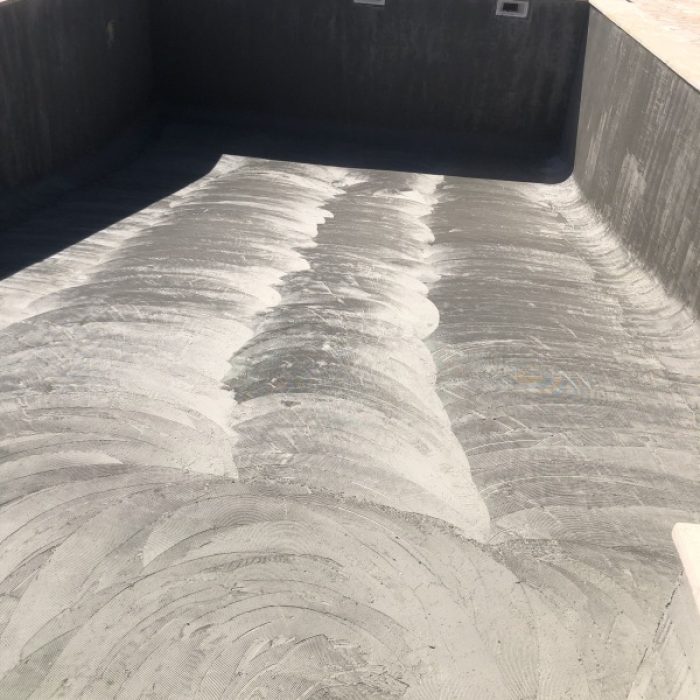 Empty countryside swimming pool showing the subtle textured patterns of a handcrafted Marblepool base before filling.