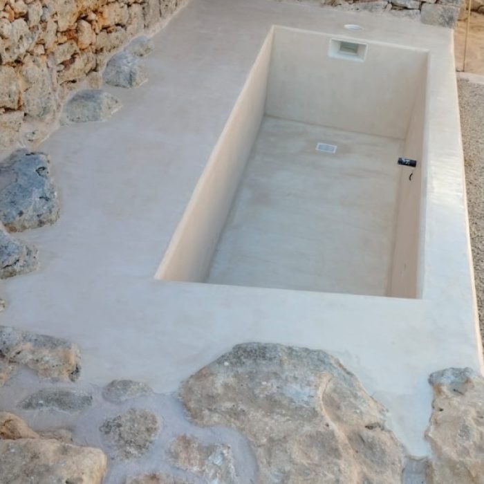 Elevated view of a rectangular swimming pool under construction in Sóller featuring a smooth Chukum mineral coating.